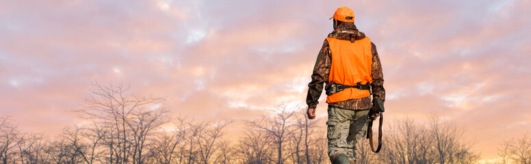 Silhouette of a hunter with a gun against the sun, an ambush for ducks.