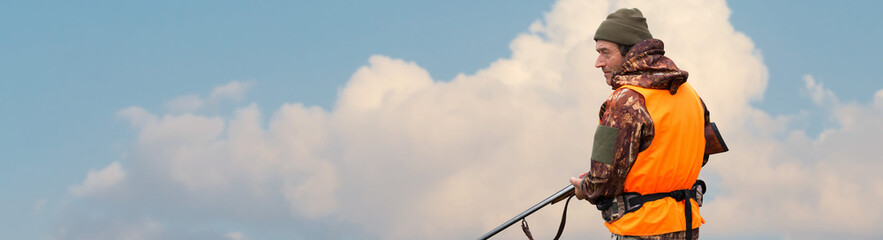 Silhouette of a hunter with a gun against the sun, an ambush for ducks.