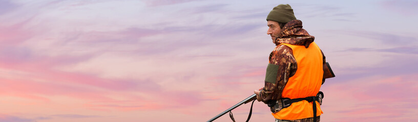 Silhouette of a hunter with a gun against the sun, an ambush for ducks.