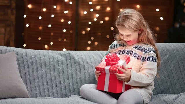 Excited girl open fairytail shining red gift box having Christmas spirit. 4k Dragon RED camera