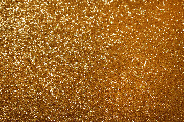 Glowing and festive gold light circles created from in camera and lens bokeh. Christmas background. Trendy color Fortuna Gold