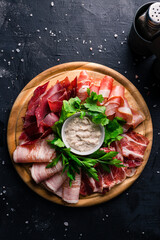 ham and Parma on a round wooden Board