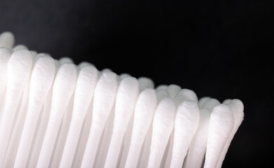 Macro shot set of white cotton swabs on black background.