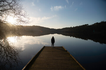 Persona mirando un lago de Mouriscot al atardecer