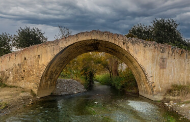 Obraz premium The beautiful arched bridge of Prevelis crossing the Megas River which empties at the famous beach of Preveli. Built in the 18th century by monks of the Prelevi, Southern Crete, Greece