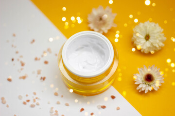 Skin product presentation. Moisturizer with active natural ingredients on yellow and white backdrop