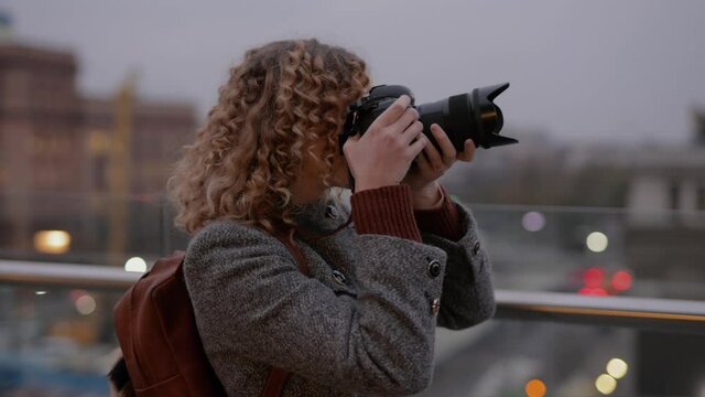Woman photographer make a photos on camera in a city