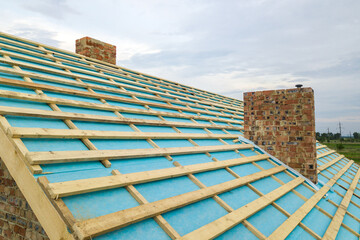 Aerial view of a wooden roof frame of brick house under construction.