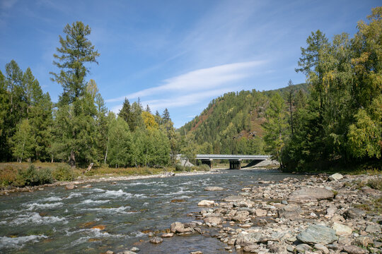 A Stone Humpback Bridge Over A River In Nature