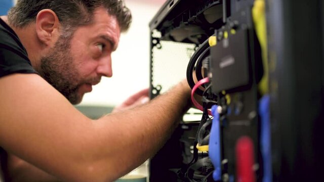 White man assembling his own computer himself at home close up