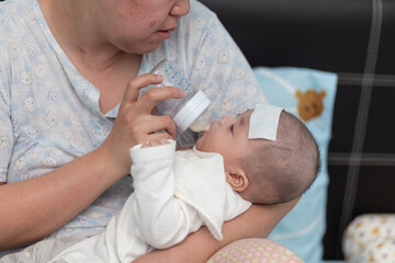 Mother on feeding 4 month baby boy milk during baby having high fever