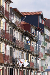 Fototapeta na wymiar Man on balcony in front of historic house facade in the old town of Porto