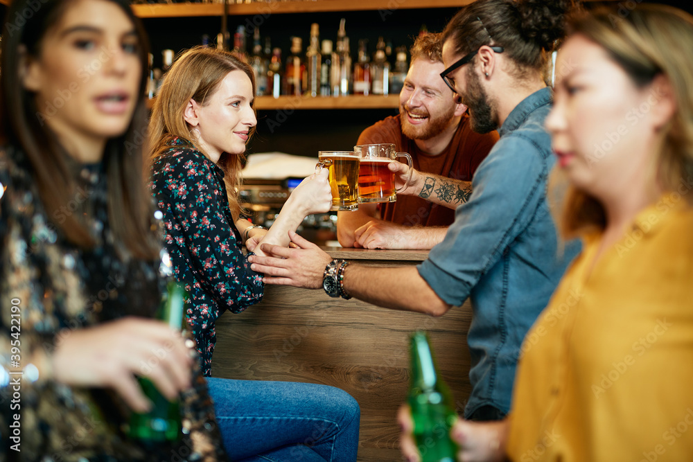 Canvas Prints Multicultural group of best friends sitting in a pub, chatting and drinking beer.