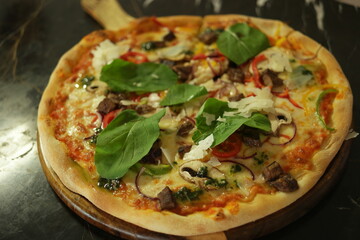 Delicious freshly baked Italian pizza. Cooking pizza at restaurant. Pesto pizza recipe.