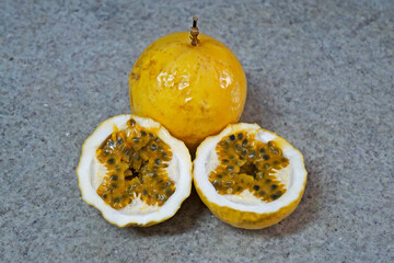 Whole passion fruits and a half in a granite background