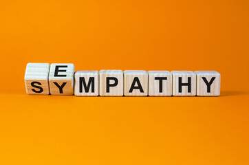 Erom sympathy to empathy. Turned cubes and changed the word 'sympathy' to 'empathy'. Beautiful orange background. Copy space. Psychological, sympathy and empathy concept.