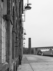 View on a street in Brest, a city located in Brittany, western France. Photographed in black and white. Cloudy sky.
