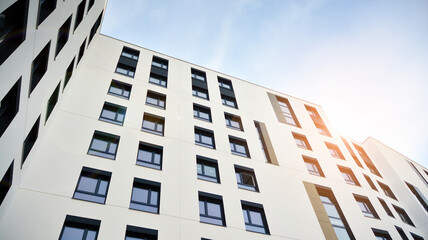 Modern apartment buildings on a sunny day with a blue sky. Facade of a modern apartment building. Glass surface with sunlight.