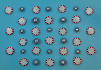 Round Peppermint candy sweet food pattern on blue paper background for winter, Christmas, New Year's, December, flat lay 