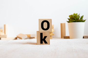 Word OK made with building blocks on white background with reflection.