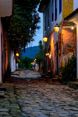 Fototapeta na wymiar Dusk view of the city of Paraty with its old colonial style houses, lanterns and the brightness and colors of the city lights reflected in the cobbled streets