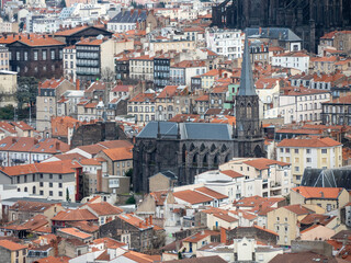 Fototapeta na wymiar View on the roofs of Clermont-Ferrand, in Auvergne region, France. We can see the bell tower of a church.