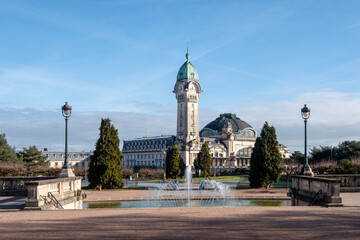Naklejka premium View on a park in Limoges. in the background there is the Limoges-Bénédictins train station (French: Gare de Limoges-Bénédictins). Lamp posts and fountain in the foreground. 