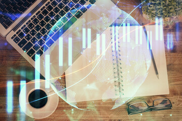 Financial market graph and top view computer on the desktop background. Double exposure. Investment concept.