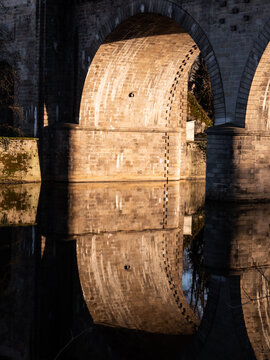 View on the arch of the bridge "Pont neuf" in Limoges, a city of France. Photographed in the evening. Reflection on the water.