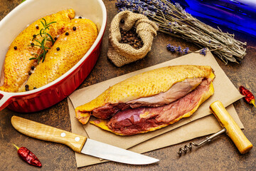 Preparation raw duck breasts with sea salt, fresh rosemary, dry lavender and chili