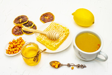 Obraz na płótnie Canvas Healing sea-buckthorn tea with honeycombs and lemon