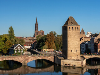 View on the famouse "La Petite France" (also known as the Quartier des Tanneurs) a historic quarter of the city of Strasbourg in eastern France. The cathedral is in the background. Blue sky.