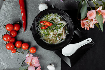 Bowl of chicken noodle on gray concrete background