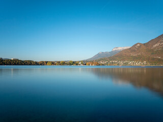 Fototapeta na wymiar Lake Annecy (French: Lac d'Annecy) is a perialpine lake in Haute-Savoie in France. Landscape in autumn, sunny day, blue sky.