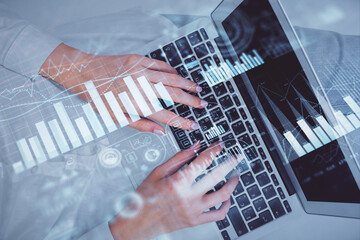 Double exposure of woman hands working on computer and forex chart hologram drawing. Top View. Financial analysis concept.