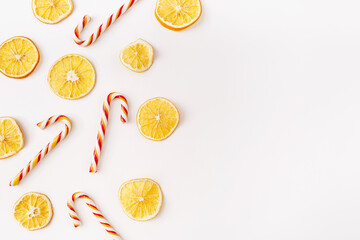 Christmas, winter, new year composition. Slices of dry oranges and candies on white background. Food background. Flat lay, top view, copy space