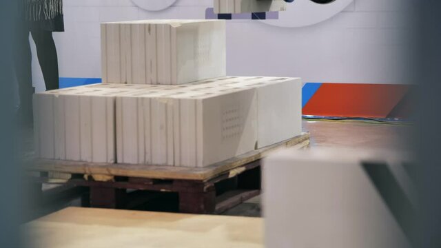 Concept of replacement humans by robotic technologies in construction industry. Media. Future of artificial intelligence, robot making a wall of blocks at the exhibition.