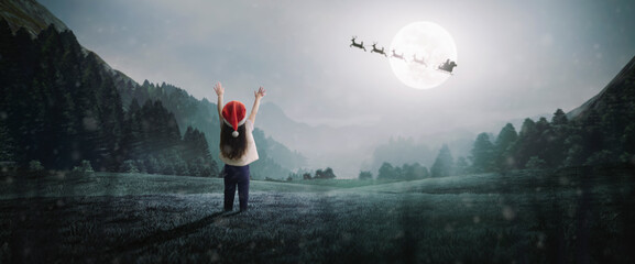 little girl surprised to see Santa Claus on beautiful Christmas night under moonlight in mountains