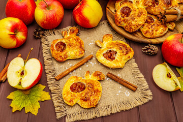 Naklejka na ściany i meble Homemade apple dessert, portioned puffs with fragrant cinnamon sticks, colorful foliage, autumn good mood