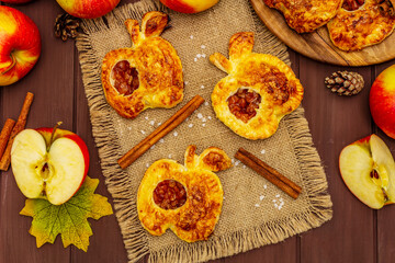 Obraz na płótnie Canvas Homemade apple dessert, portioned puffs with fragrant cinnamon sticks, colorful foliage, autumn good mood