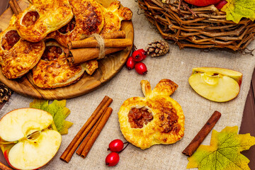 Homemade apple dessert, portioned puffs with fragrant cinnamon sticks, colorful foliage, autumn good mood