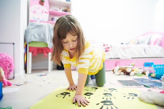 cute little girl at home painting with hands
