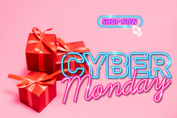 Fototapeta na wymiar red gift boxes near shop now, cyber monday lettering on pink blurred 
