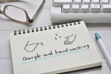 There is a keyboard, glasses, and a notebook on the desk with an illustration of 