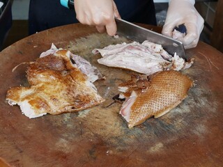 vendor slicing pot stewed duck fillet on a wooden cutting board at street food.