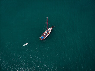 Aerial view of a  sailing yacht  with white kayak in the turquoise water of the Andaman sea. Phuket. Thailand