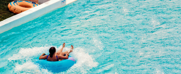 Cool people having fun on the water slide with friends and familiy in the aqua fun park glides...