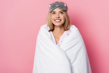  woman in blindfold and blanket looking up on pink background