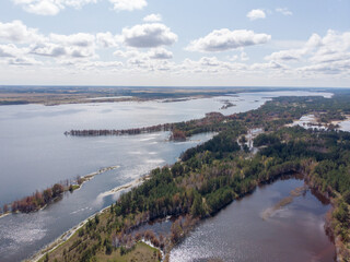 Beautiful scenic view of high mountain hillsides covered with soft wood forest and green fields, distant rugged rock