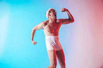 Strong young new year man with muscular body. Strong man. Funny photo. Happy New Years. Fun. Photo. Studio. 